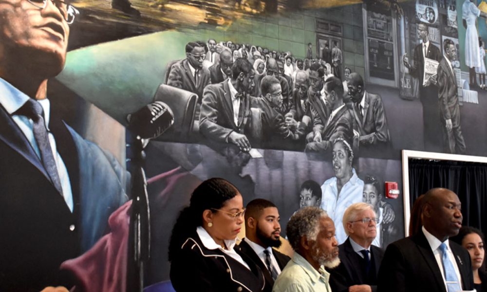Attorney Ben Crump (at podium) with Malcolm X’s daughter, Dr. Ilyasah Shabazz, and Khaleel Sultarn Sayyed at a press conference on February 21. Credit: Ariama C. Long photo