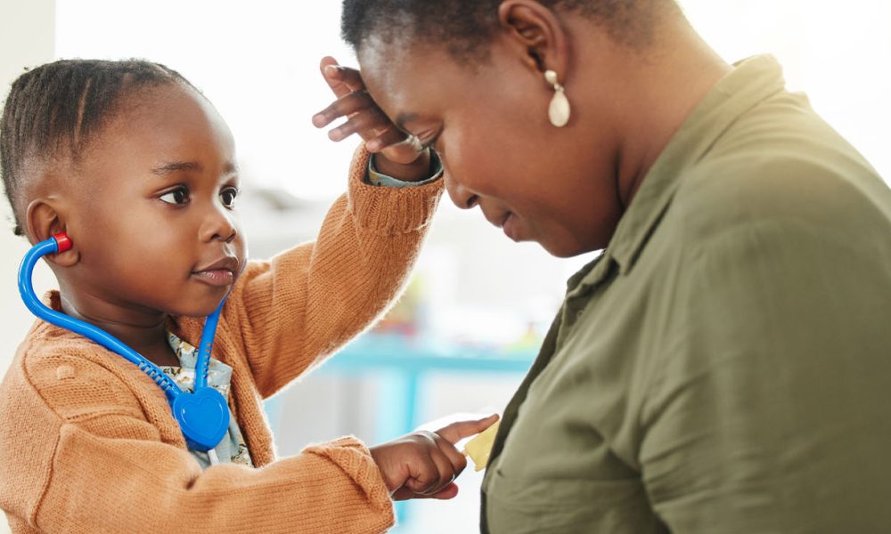 Little girl playing doctor while listening to her mother’s chest (Photo Credit by peoplelmages)