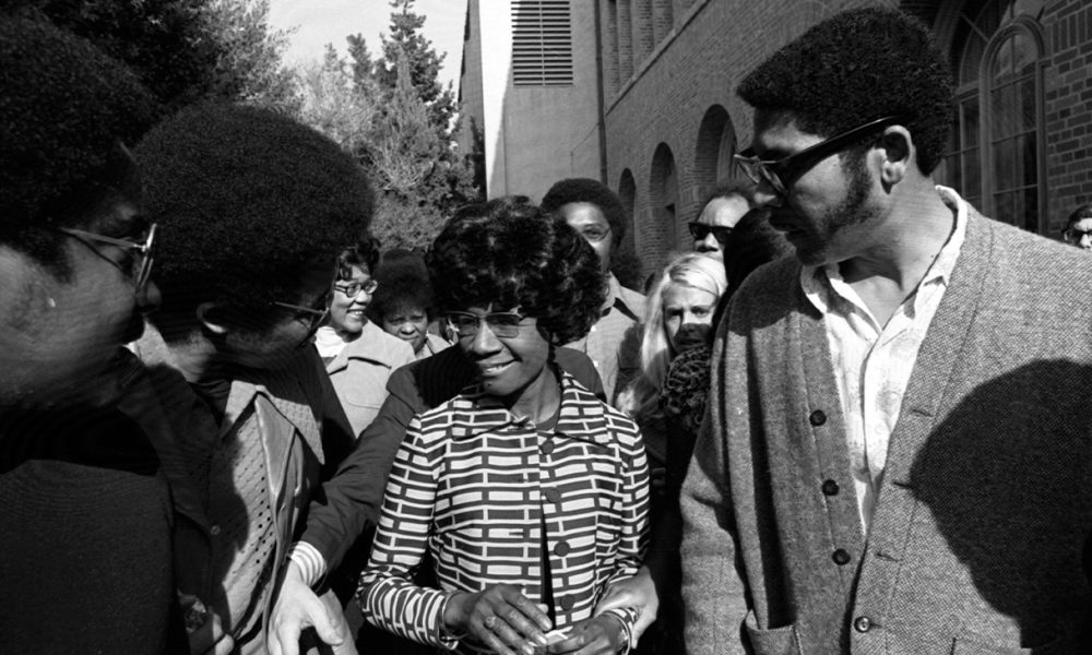 ON 'CHISHOLM TRAIL'—Shirley Chisholm leaves USC's Bovard Auditorium, where she said Presidency should not be exclusive domain of white males." 24 January 1972. Photo: Tony Barnard, Los Angeles Times.