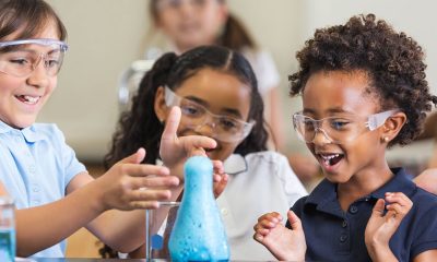 Excited girls using chemistry set together in elementary science classroom