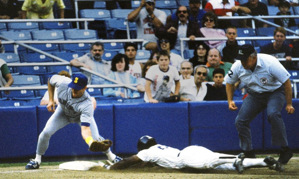 Rickey Henderson with the New York Yankees, steals third base under the tag of third baseman Jim Presley as umpire Larry Barnett observes during the first game of a doubleheader against Seattle on August 19, 1988. It was his 70th steal of the season. Photo: Rdikeman on en.wikipedia.