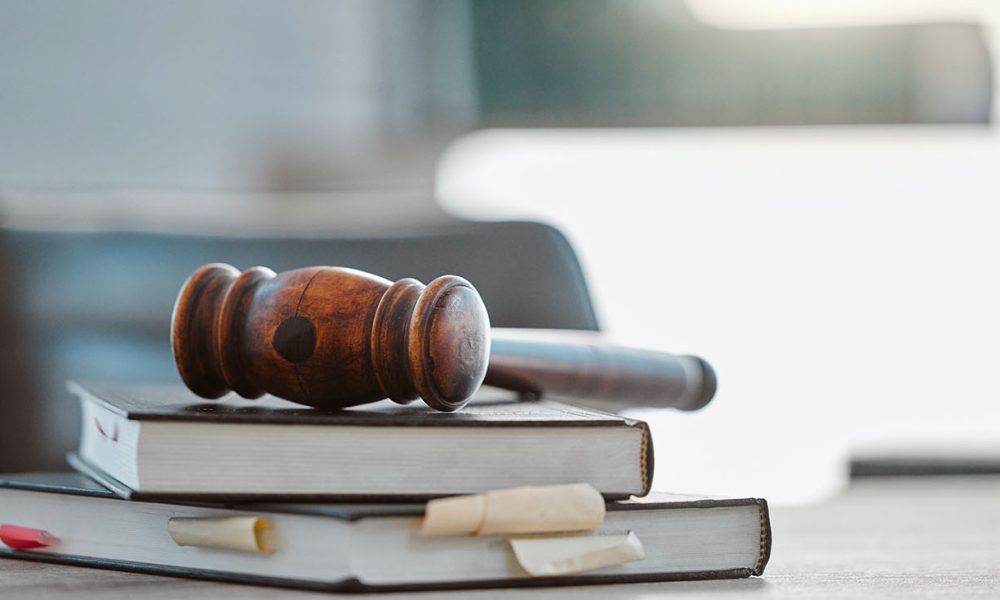 Justice, gavel and law books on table in office for court trial (Photo By Jacob Wackerhausen)