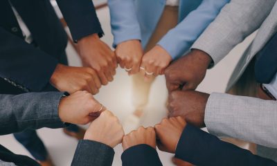Businesspeople, teamwork and fist of hands in circle for collaboration, synergy and motivation of global equality from above (Photo By Jacob Wackerhausen)
