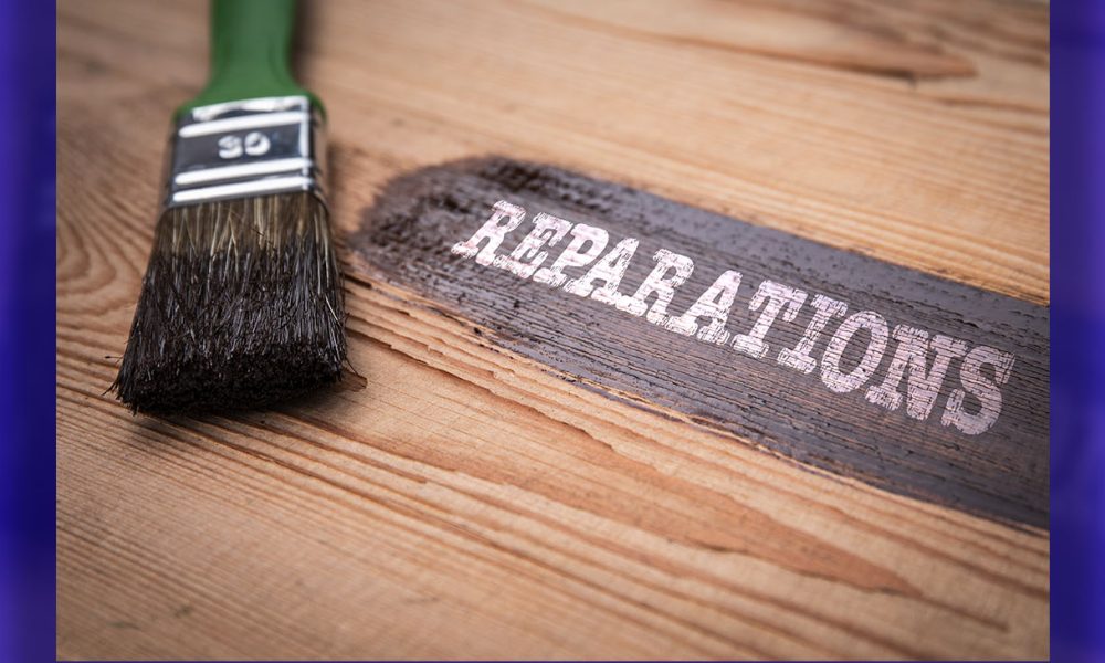 Reparations Concept. Green brush and painted wooden board with text.
