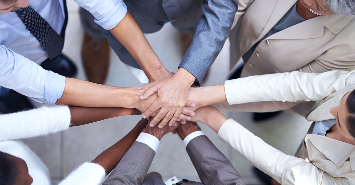 Shot of a group of coworkers with their hands in a huddle