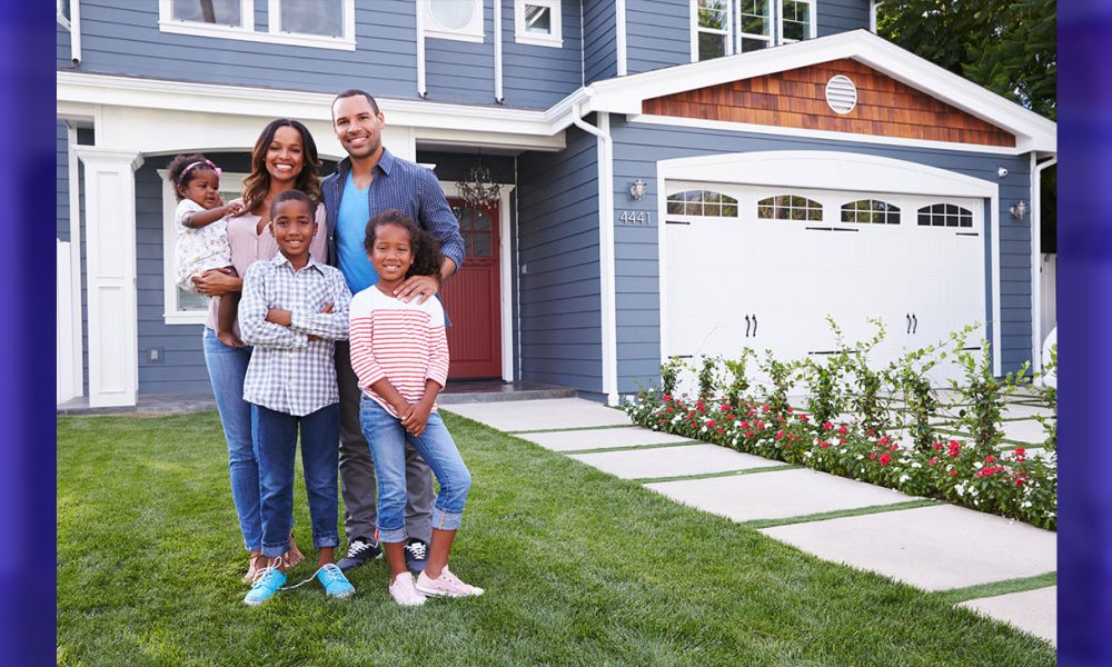 Happy family standing outside their house