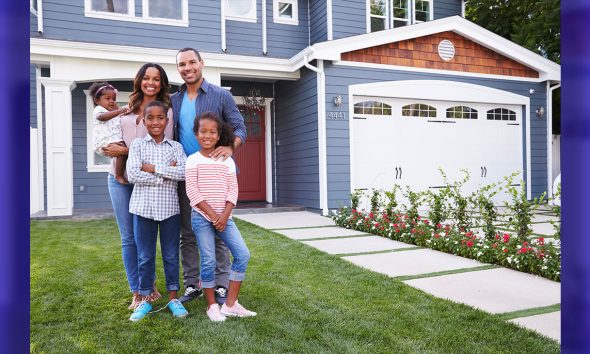 Happy family standing outside their house
