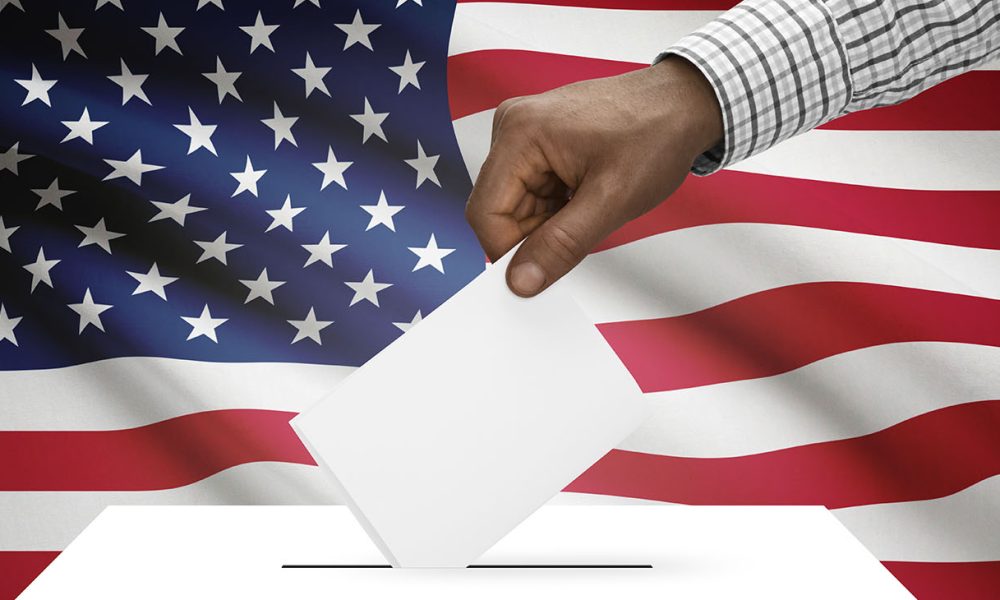 Ballot box with national flag on background United States of America (Photo by Serhej Calka)