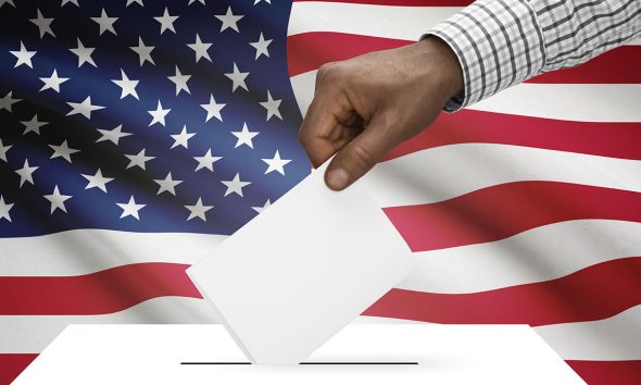 Ballot box with national flag on background United States of America (Photo by Serhej Calka)
