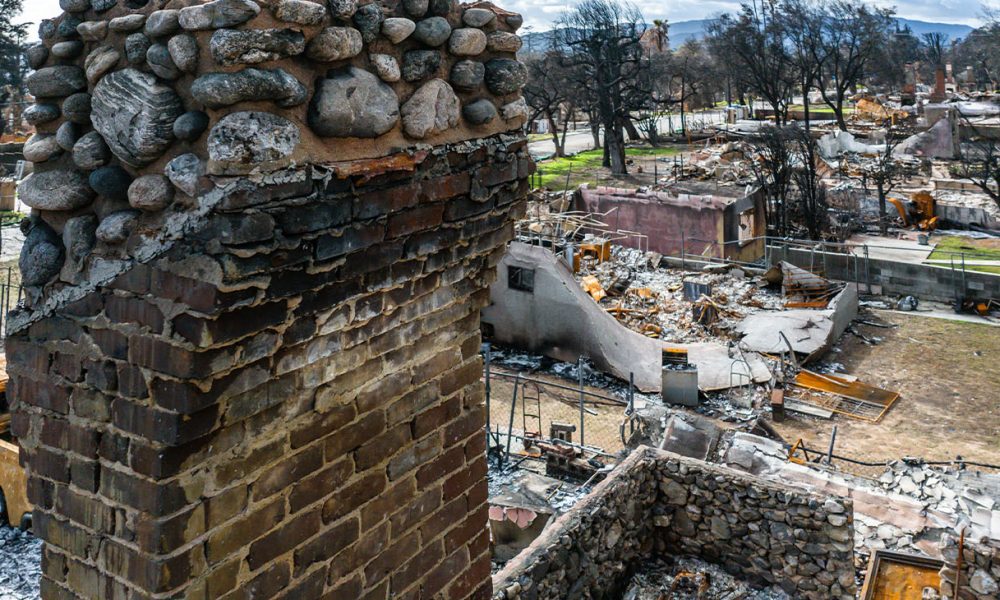 A fireplace is all that remains after a fire destroys the entire house. The rubble surrounds it (Photo by Brian Koester)