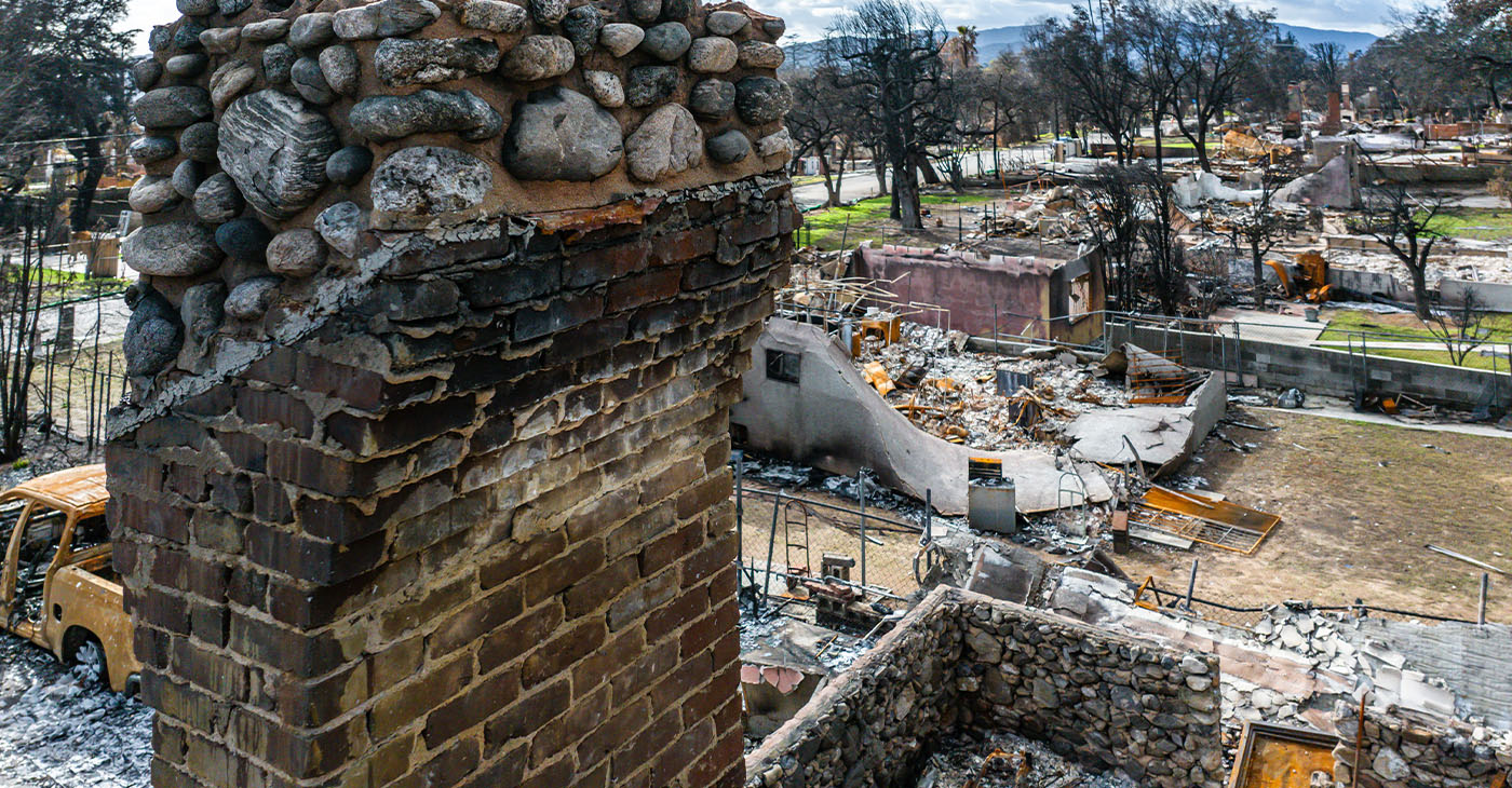 A fireplace is all that remains after a fire destroys the entire house. The rubble surrounds it (Photo by Brian Koester)