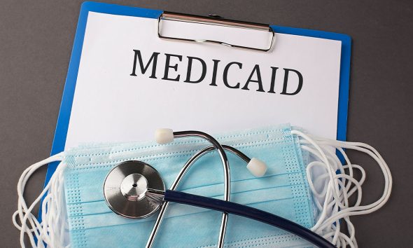 Folder with paper text MEDICAID , on a table with a stethoscope and medical masks, medical (Photo by Iryna Drozd)