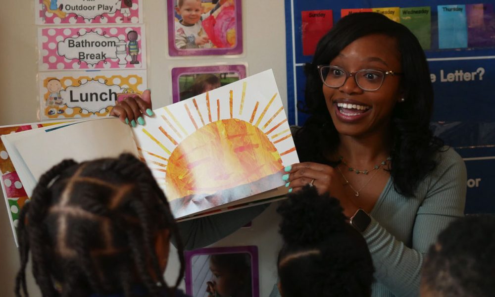 Shalicia Jackson reads a book to children at Modern Early Learning Academy, her family childcare home in Winston-Salem. Photo by: Liz Bell, EdNC