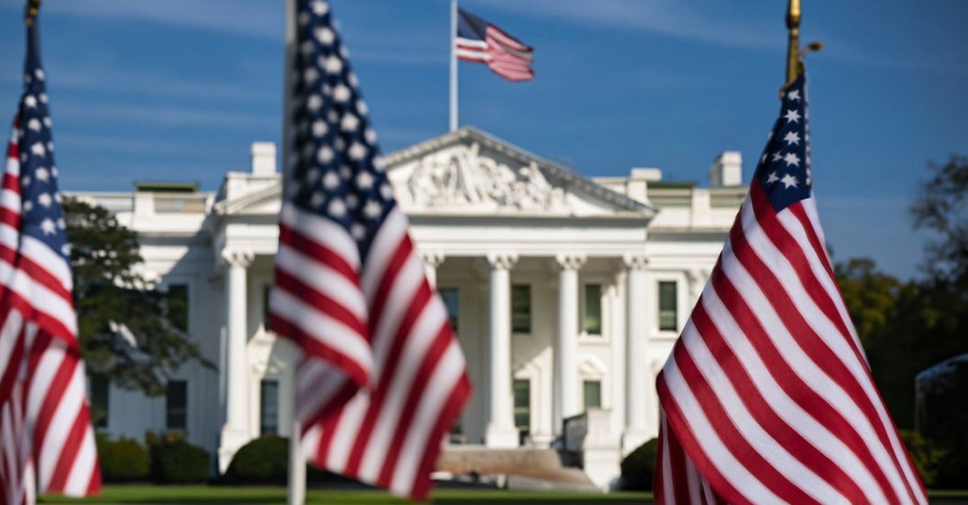 This compelling photograph captures the essence of American democracy with a captivating view of the White House in the background, framed by a row of American flags in the foreground. The flags, symbolizing the nation's unity and resilience, stand proudly in front of one of the most iconic landmarks in the United States. (Photo by Castle City Creative)