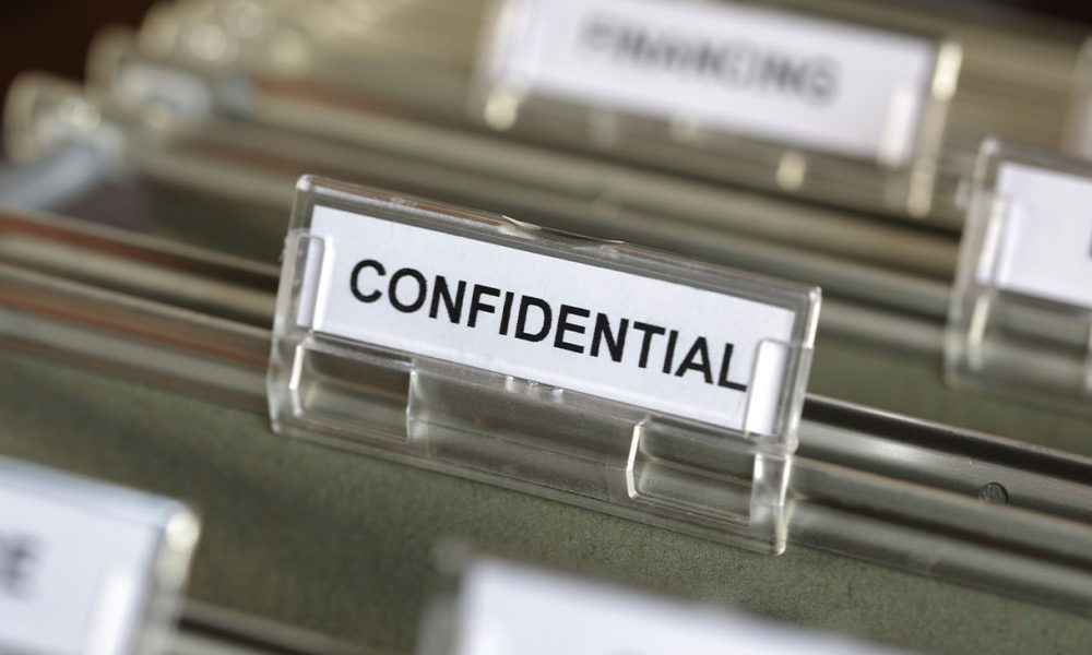 Inside of a filing cabinet with green folders and focus on confidential label (Photo by Brian A Jackson)