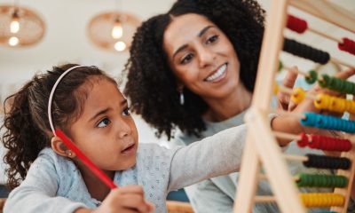 Math, child learning and mother for home education, numbers support or helping in kindergarten development. Happy mom, woman and girl kid writing abacus numbers on paper, school and family teaching (Jacob Wackerhausen)