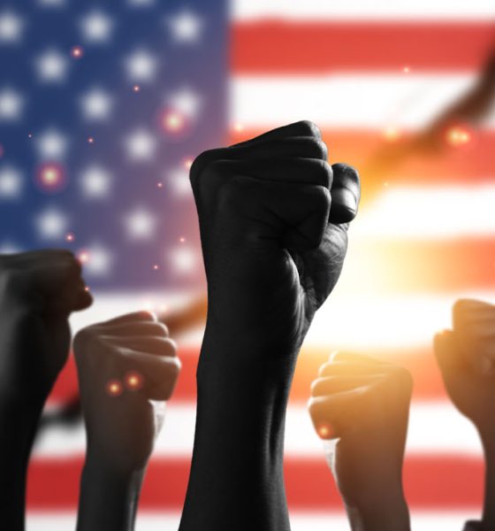 American flag with black people raise their hands to protest in the United States for racism and racial inequality.