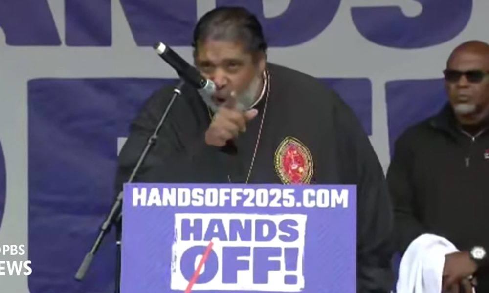 Rev. Dr. William Barber, the former President of the North Carolina NAACP who is currently the President of Repairers of the Breach speaks at the “Hands Off!” 2025 protest rally. Photo: Screen capture from PBS News live broadcast of the event.