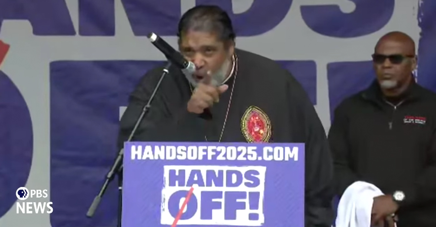 Rev. Dr. William Barber, the former President of the North Carolina NAACP who is currently the President of Repairers of the Breach speaks at the “Hands Off!” 2025 protest rally. Photo: Screen capture from PBS News live broadcast of the event.