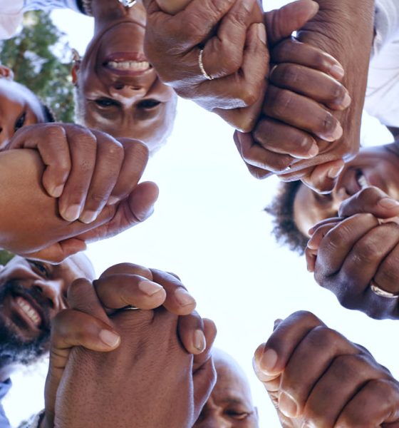 Holding hands, community support or family in nature for bonding or playing in a park together. (Photo by Jacob Wackerhausen)