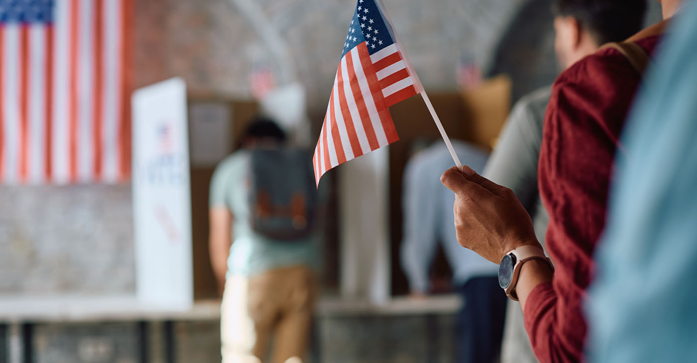 Close up of African American voter with national flag in waiting line during US elections. (Photo by Drazen Zigic)