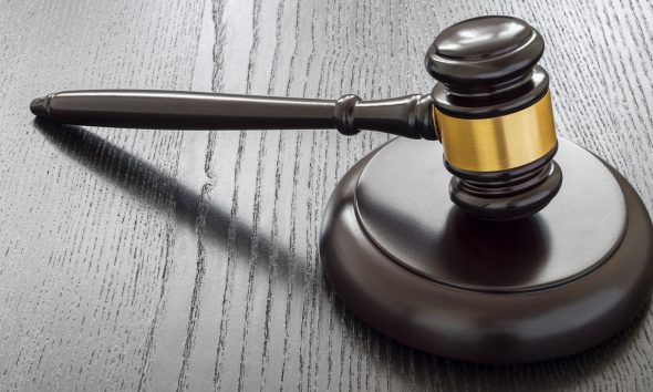Wood gavel and open handcuffs symbolizing freeing judge decisions