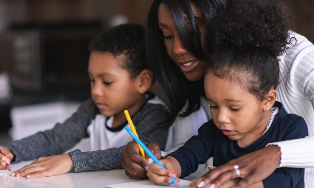 Two mixed race children of elementary school age attend class from home. School has been cancelled due to the COVID-19 Pandemic.