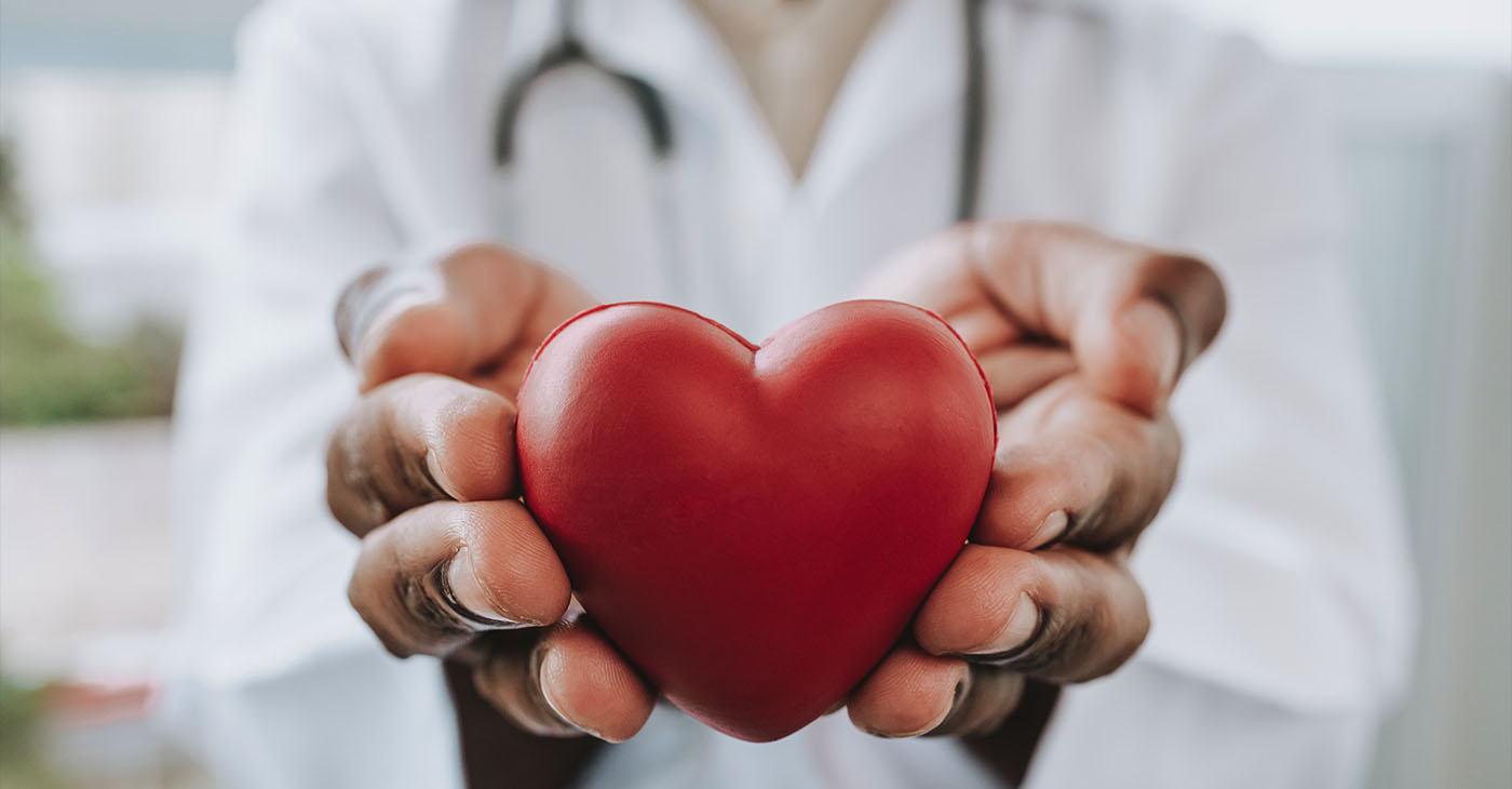 Portrait of a doctor holding a heart in his hands (Photo by Andres)