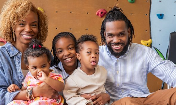 Little boy with Down Syndrome with his parents and sisters ( Photo by Courtney Hale)