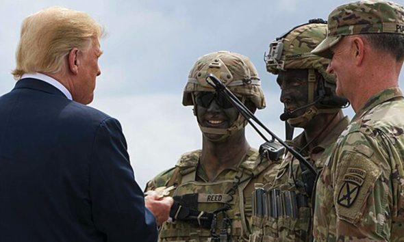 President Donald J. Trump is presented with a 10th Combat Aviation Brigade challenge coin following an air assault and gun rain demonstration at Fort Drum, New York, on August 13. The demonstration was part of President Trump's visit to the 10th Mountain Division (LI) to sign the National Defense Authorization Act of 2019, which increases the Army's authorized active-duty end strength by 4,000 enabling us to field critical capabilities in support of the National Defense Strategy. (U.S. Army photo by Sgt. Thomas Scaggs) 180813-A-TZ475-010 (Wikimedia Commons / Photo by U.S. Army photo by Sgt. Thomas Scaggs)