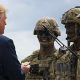 President Donald J. Trump is presented with a 10th Combat Aviation Brigade challenge coin following an air assault and gun rain demonstration at Fort Drum, New York, on August 13. The demonstration was part of President Trump's visit to the 10th Mountain Division (LI) to sign the National Defense Authorization Act of 2019, which increases the Army's authorized active-duty end strength by 4,000 enabling us to field critical capabilities in support of the National Defense Strategy. (U.S. Army photo by Sgt. Thomas Scaggs) 180813-A-TZ475-010 (Wikimedia Commons / Photo by U.S. Army photo by Sgt. Thomas Scaggs)