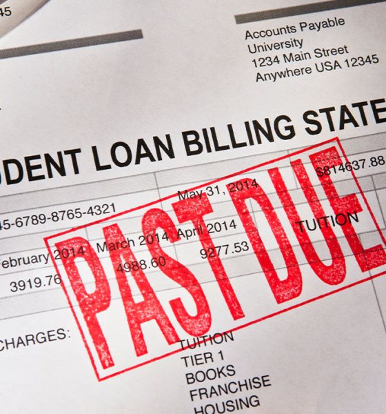 Statement for a Student Loan on a desktop. Loan is PAST DUE with a red rubber stamp. Props include reading glasses, coffee cup and pen. Horizontal photograph. PAST DUE is bright red against the white form. Shot from a high angle looking down. Dramatic lighting with some shadows.
