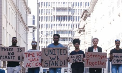 Protest group activism, justice portrait and change in street with poster in hands. Crowd people writing, city sign for solidarity peace or diversity of race, religion and community in metro together (Photo by Armand Burger)