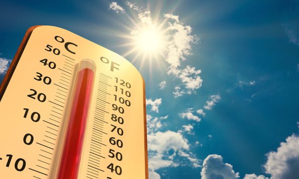 climate change, low angle view Thermometer on blue sky with sun shining in summer show increase temperature, concept global warming