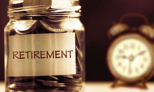 Close up Coins in glass jar with alarm clock for time to money saving for retirement concept , vintage color tone