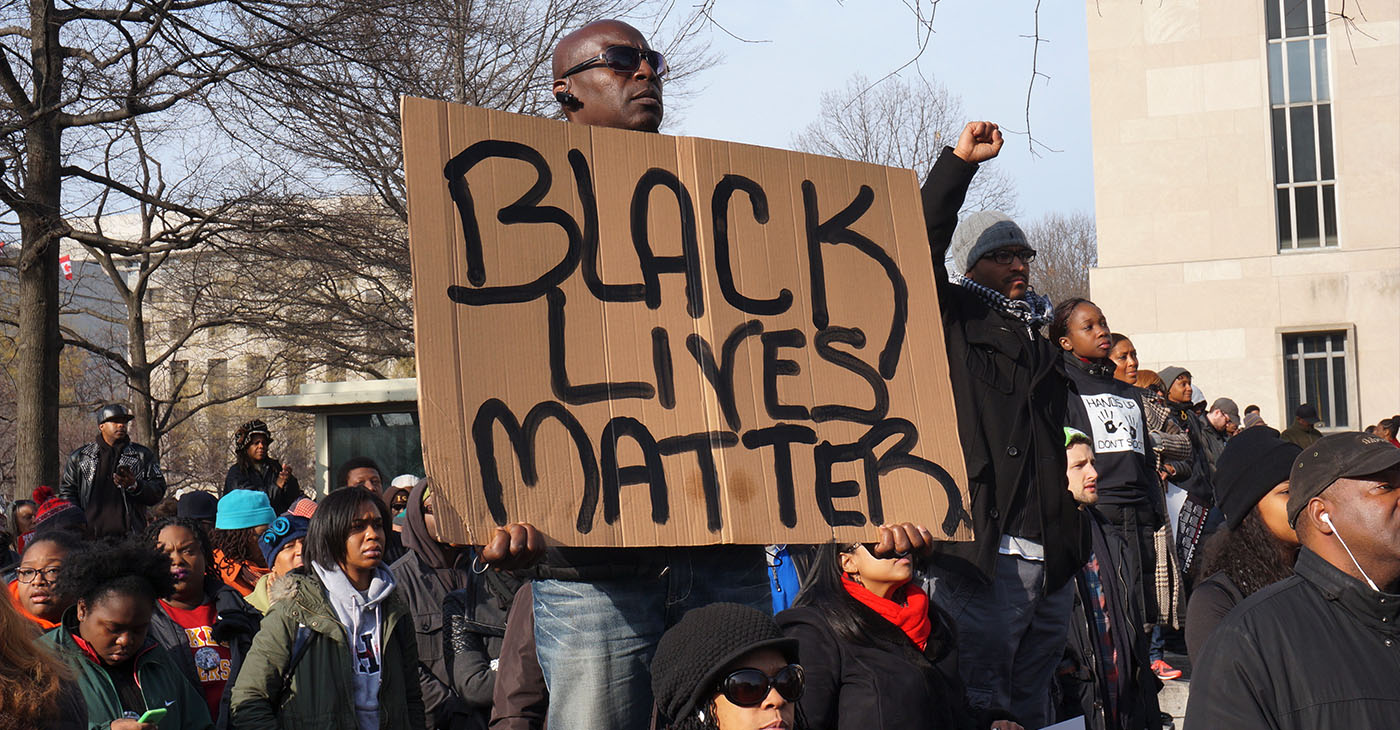 Washington DC, USA-December 13, 2014: This man is protesting police brutality at a protest led by Reverend Al Sharpton on Pennsylvania Avenue in Washington DC. He displays a sign with the message Black Lives Matter. Recently the deaths of Michael Brown, Eric Garner and Tamir Rice have upset the black community.