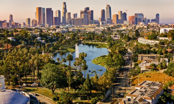 Aerial view of Echo Park Lake surrounded by neighbourhood with high rise office buildings in background, City Of Los Angeles, California, USA.