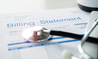 Health care billing statement with stethoscope, bottle of medicine for doctor's work in medical center stone background.