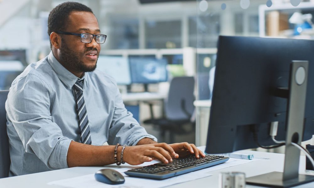 In the Industrial Engineering Facility: Portrait of the Smart and Handsome Male Engineer Working on Desktop Computer.