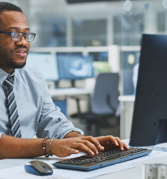 In the Industrial Engineering Facility: Portrait of the Smart and Handsome Male Engineer Working on Desktop Computer.