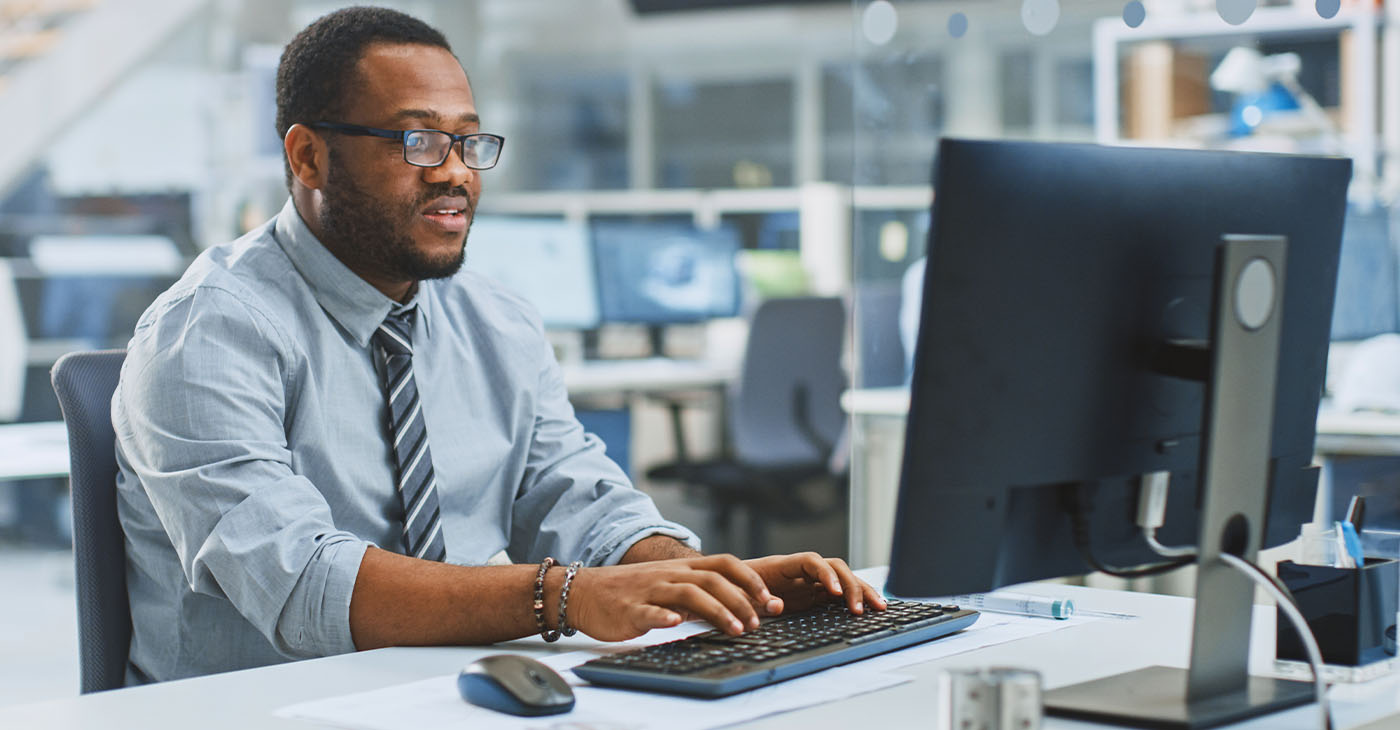 In the Industrial Engineering Facility: Portrait of the Smart and Handsome Male Engineer Working on Desktop Computer.