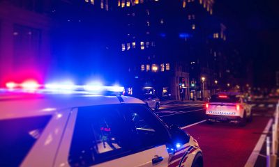 Police Car with Lights on at night in City.