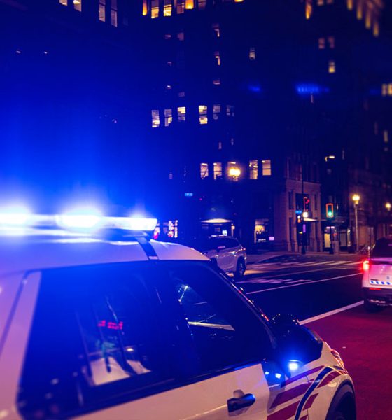 Police Car with Lights on at night in City.