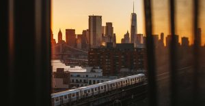 Manhattan and train view from behind a window curtain as the sun sets