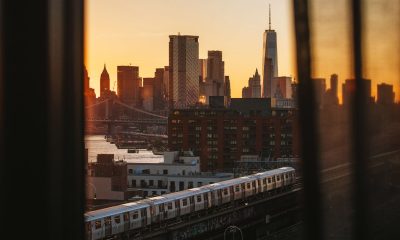 Manhattan and train view from behind a window curtain as the sun sets