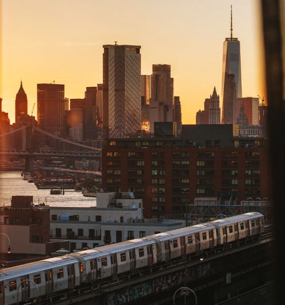 Manhattan and train view from behind a window curtain as the sun sets