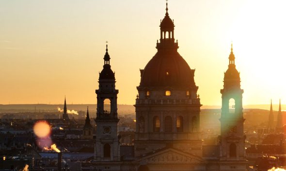 Aerial view of the famous St. Stephen's Basilica in Budapest at sunrise St. Stephen's Basilica is a Roman Catholic basilica in Budapest, Hungary. It is named in honour of Stephen, the first King of Hungary, whose right hand is housed in the reliquary. Since the renaming of the primatial see, it has been the co-cathedral of the Roman Catholic Archdiocese of Esztergom-Budapest. Today, it is the third largest church building in present-day Hungary. It is the largest church in Budapest and a World Heritage Site. (Photo by Guven Ozdemir)