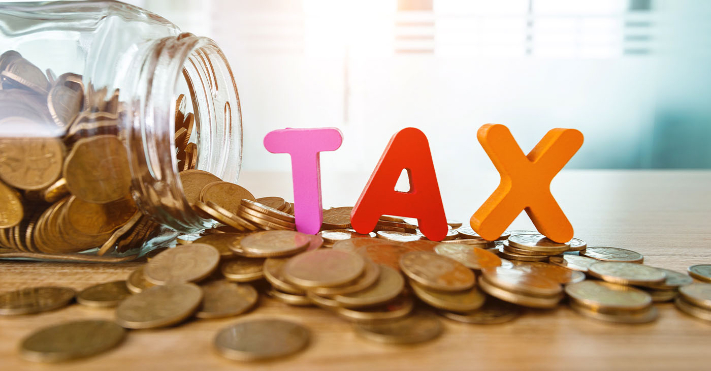 Glass jar saving coins for tax.