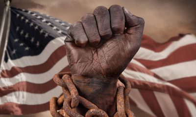Dark hand in chains with American flag behind