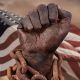 Dark hand in chains with American flag behind